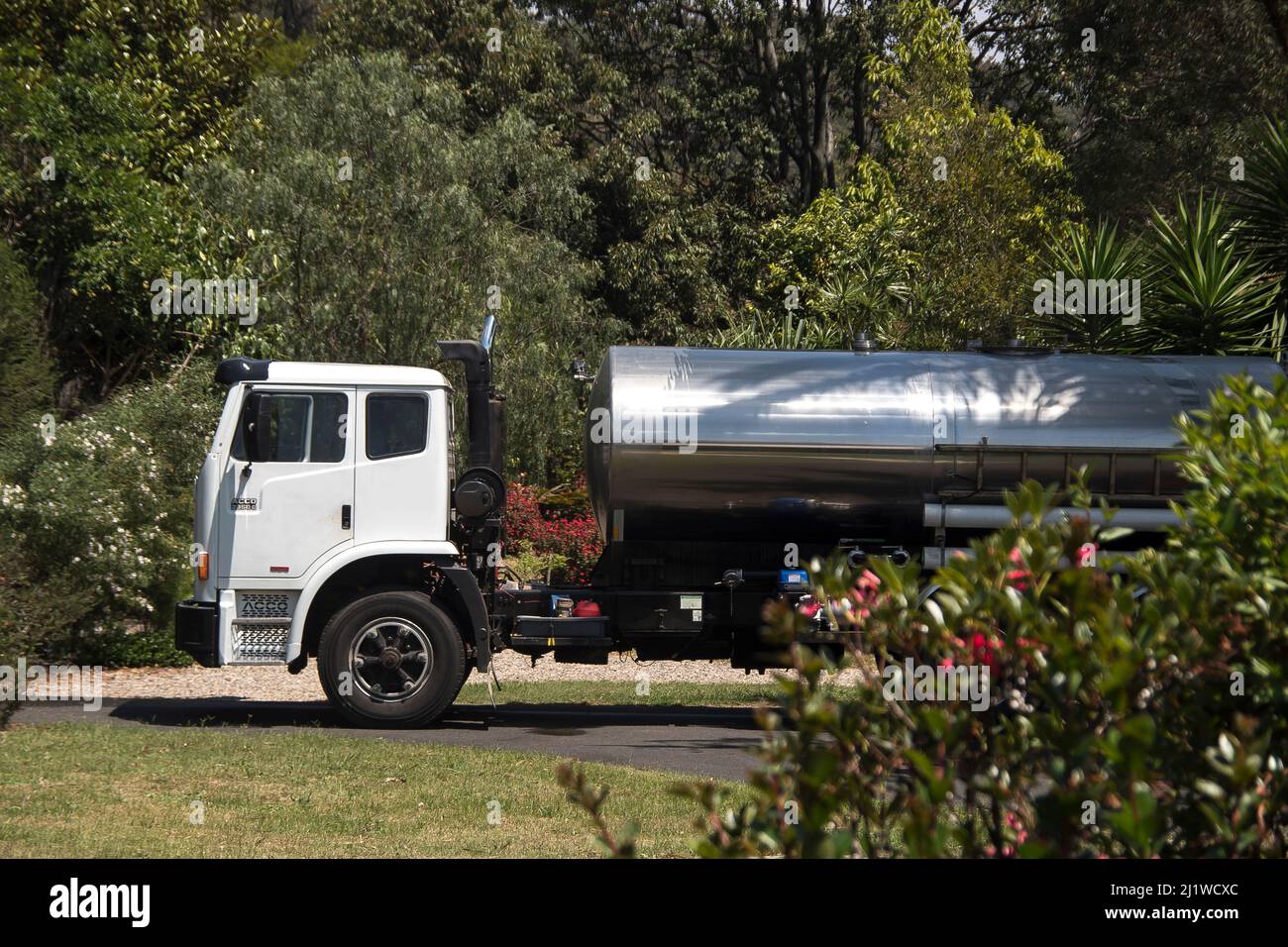 Livraison d'eau pure (potable) par camion-citerne. 12000 litres sont pompés dans le réservoir de stockage dans le jardin, après de faibles précipitations. Printemps, Queensland, Australie. Banque D'Images