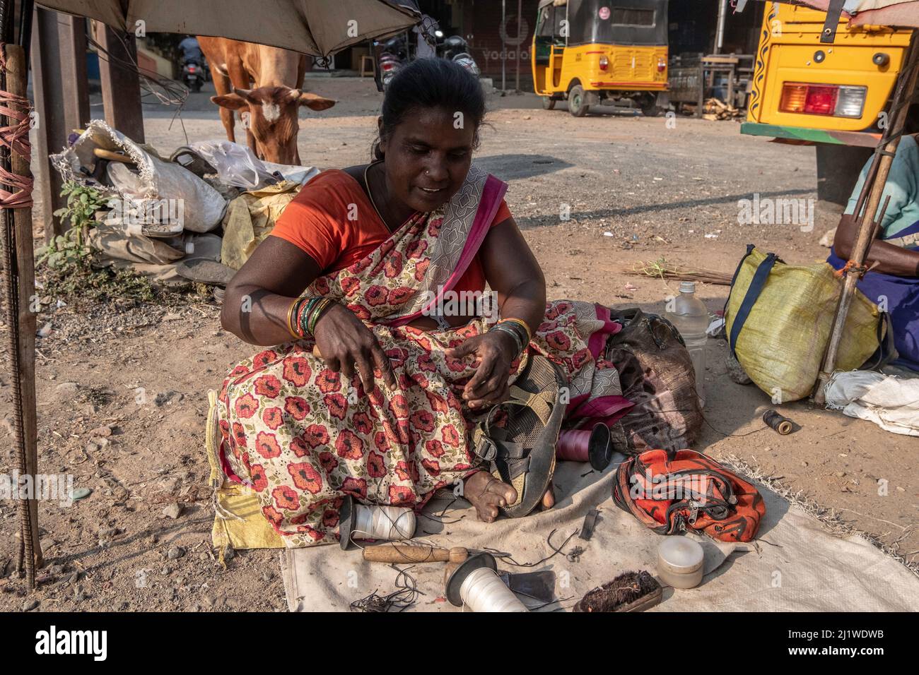 Couturière fixe et vend des vêtements usagés au marché de Tiruvannamalai, Tamil Nadu, Inde Banque D'Images