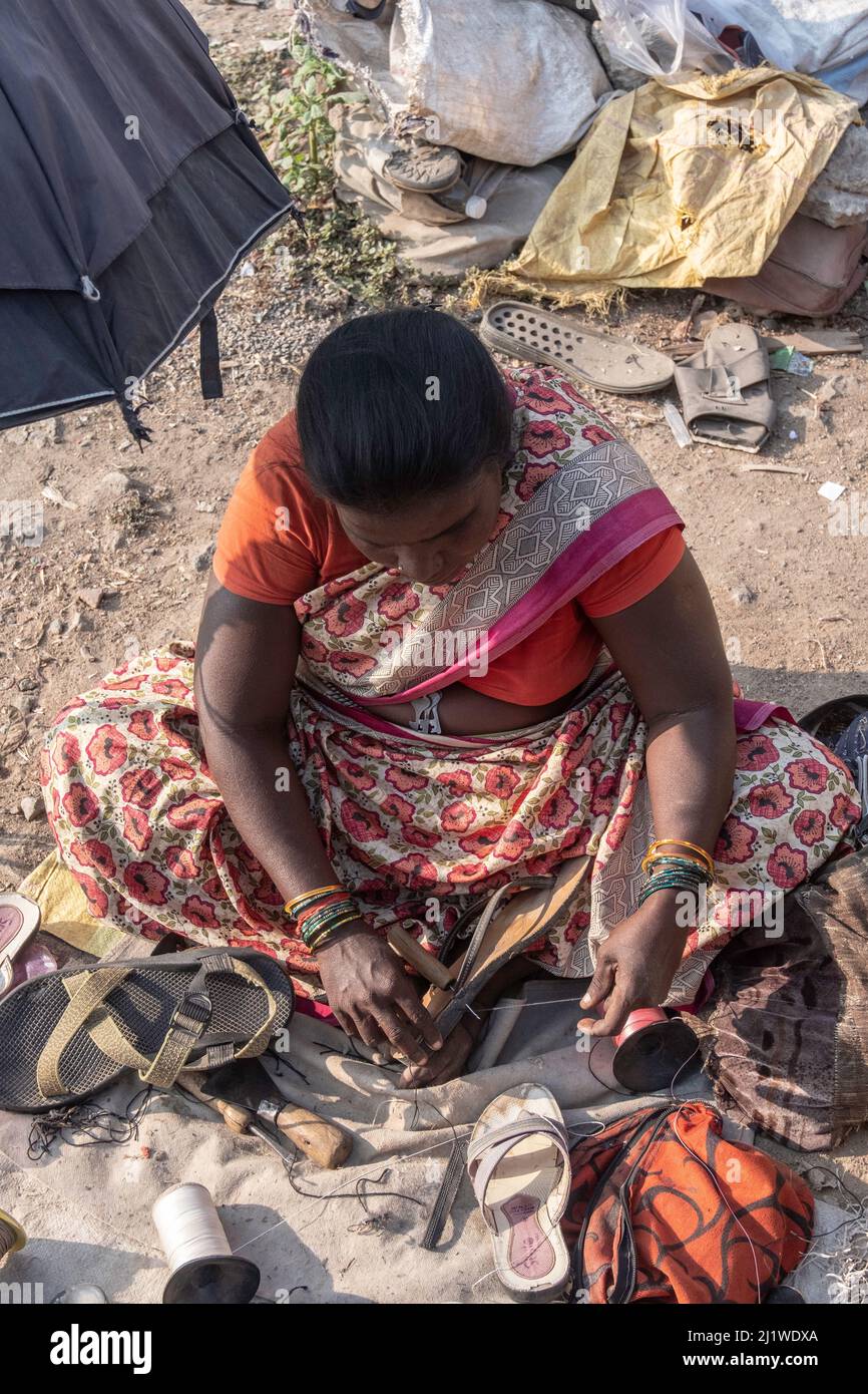 Couturière fixe et vend des vêtements usagés au marché de Tiruvannamalai, Tamil Nadu, Inde Banque D'Images