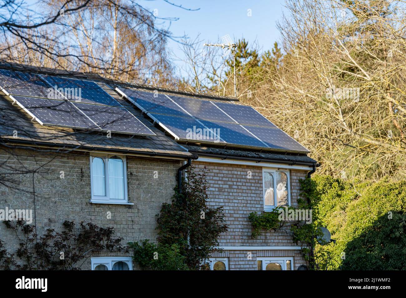 Une maison de campagne qui a eu des panneaux solaires installés sur le toit pour produire de l'énergie verte propre renouvelable et pour lutter contre le coût croissant d'energ Banque D'Images