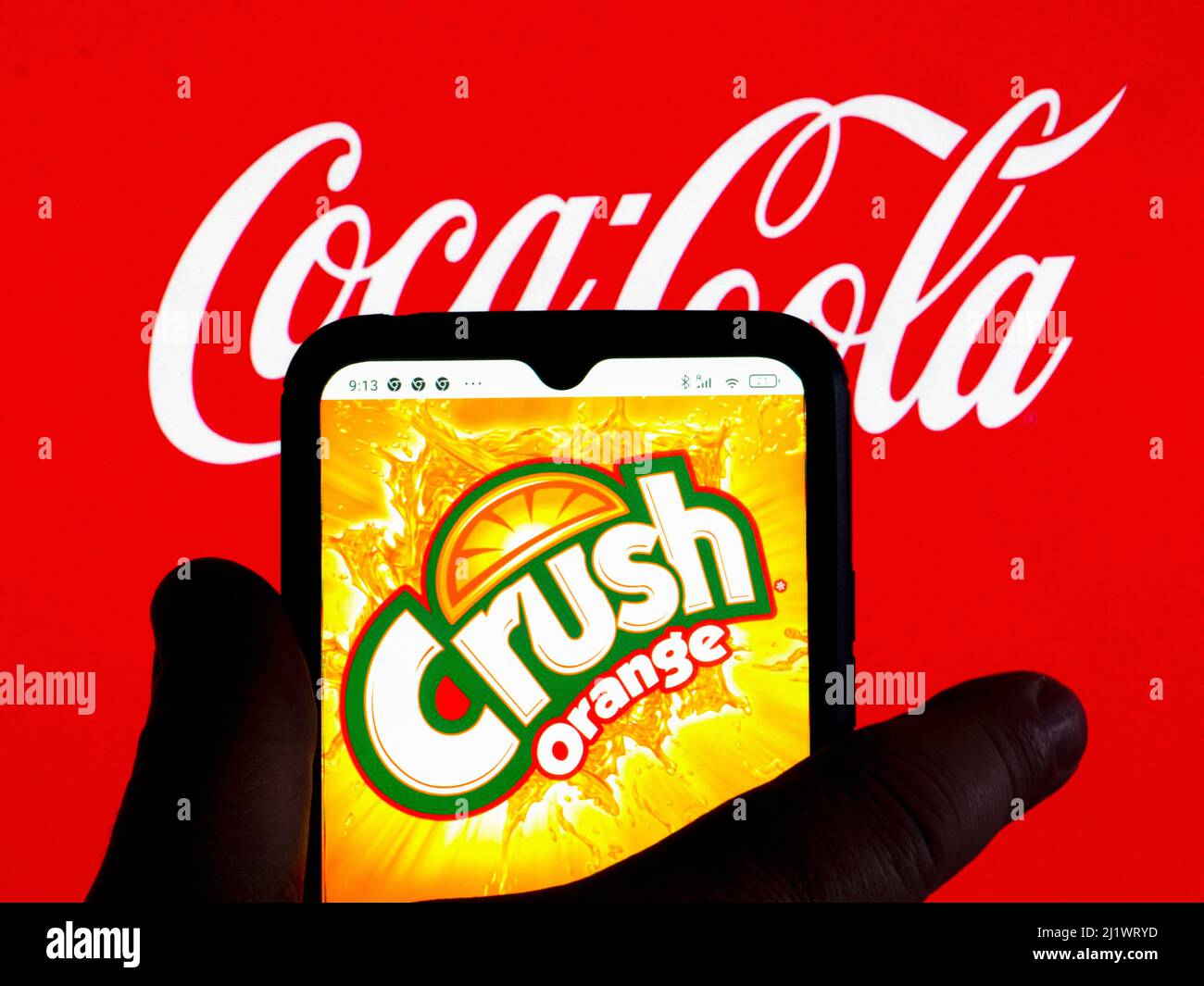 Allemagne. 28th mars 2022. Dans cette illustration, le logo de la boisson Orange Crush est affiché sur l'écran d'un smartphone avec un logo Coca-Cola en arrière-plan. Crédit : SOPA Images Limited/Alamy Live News Banque D'Images