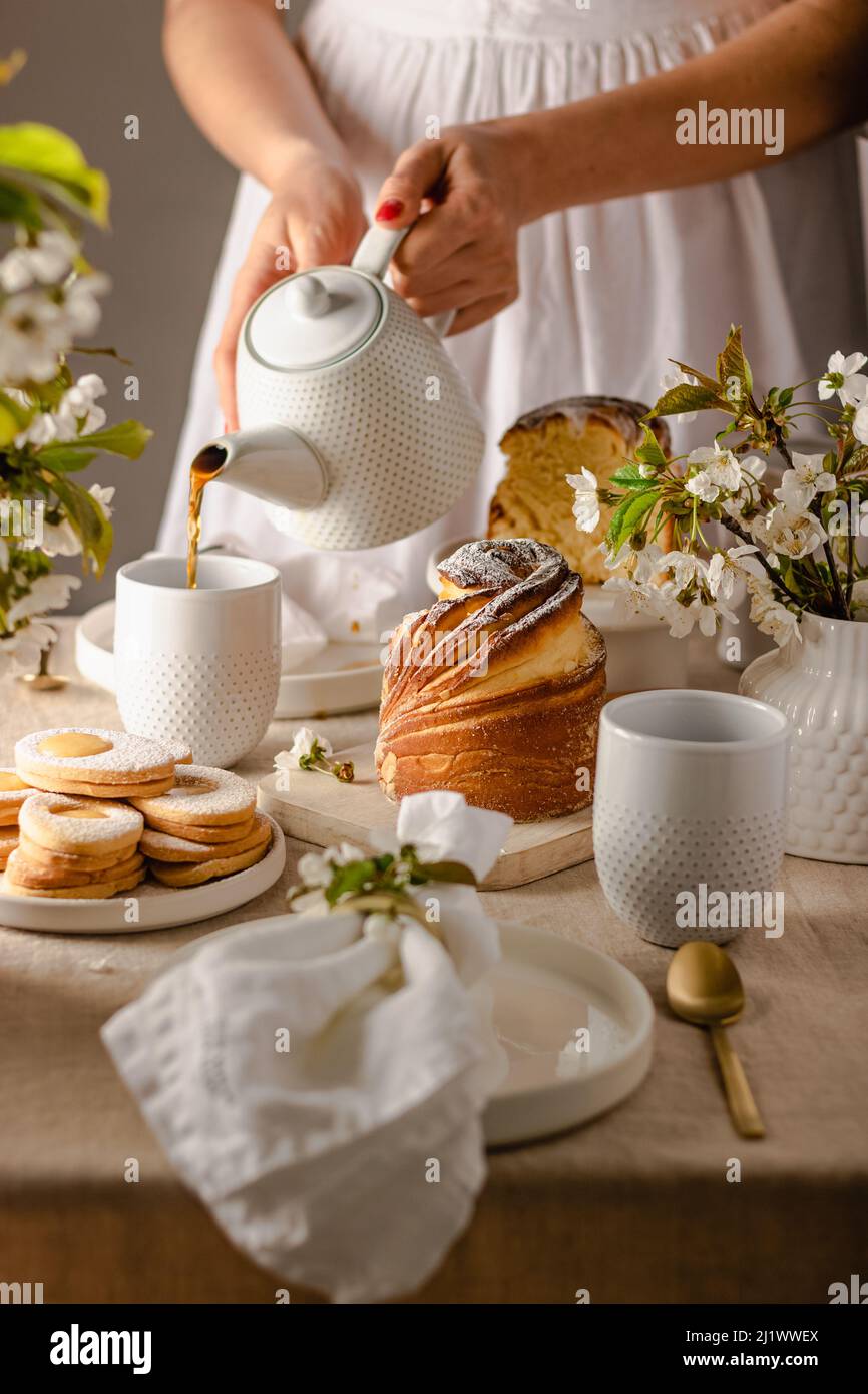 Joyeuses Pâques.Gâteau traditionnel de Pâques, kraffin maison avec raisins secs, fruits confits .cerisier fleuri sur fond blanc beton.Selective focus.Close u Banque D'Images