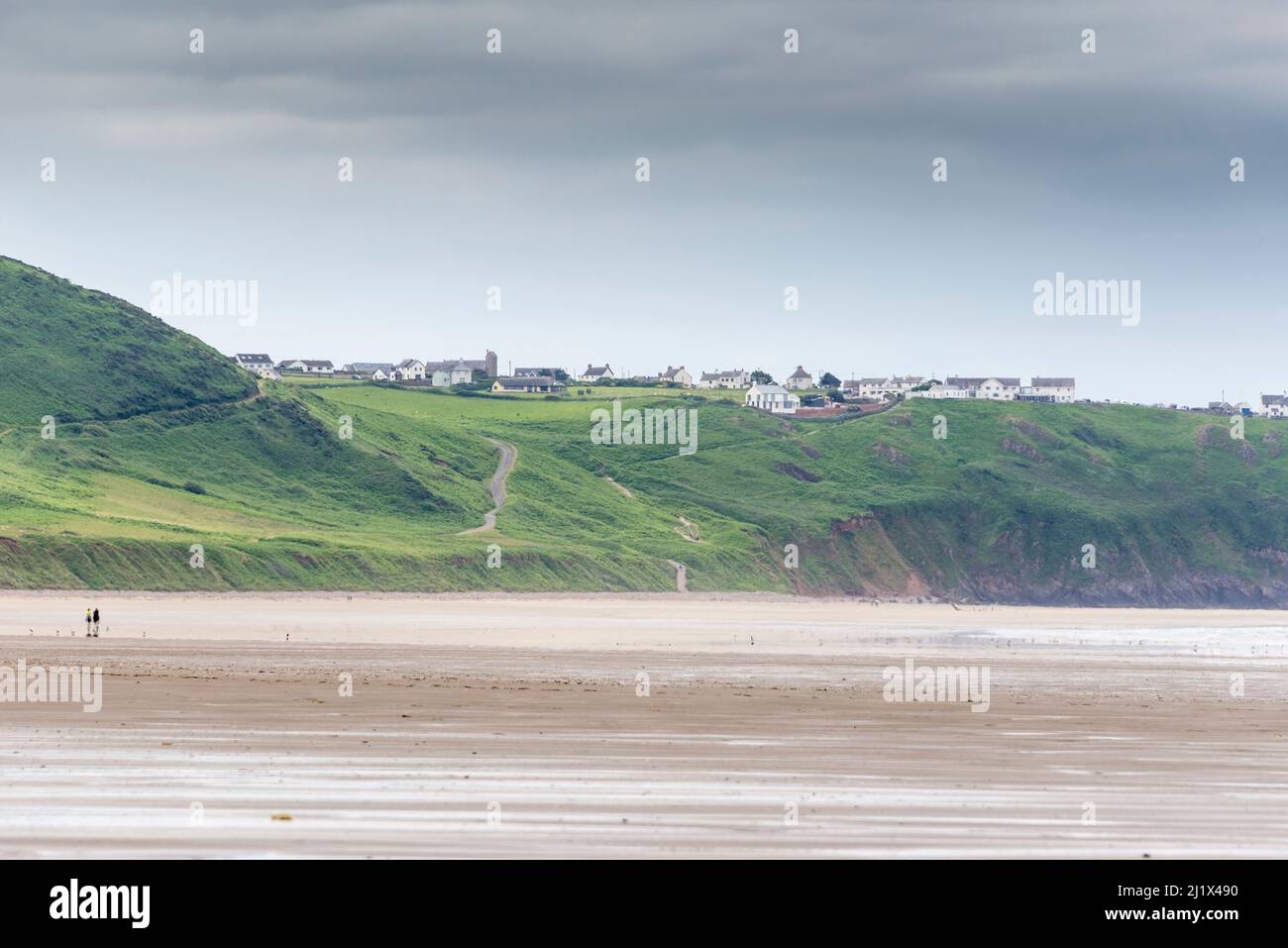 Une vue panoramique sur l'immense plage de sable de la baie de Rhossili à marée basse. Au loin se trouve Rhossili et le village de Rhossili, au sommet d'une falaise. Banque D'Images