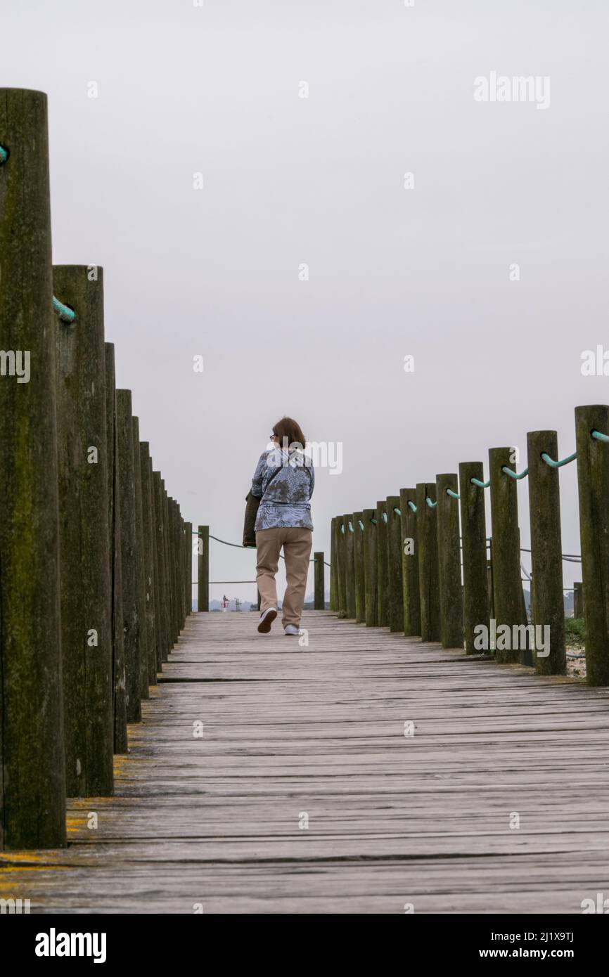 Adultes seules les femmes marchent sur la promenade en bois de la plage. Des promenades saines près de la plage. Des femmes célibataires qui marchent près de la plage. Banque D'Images