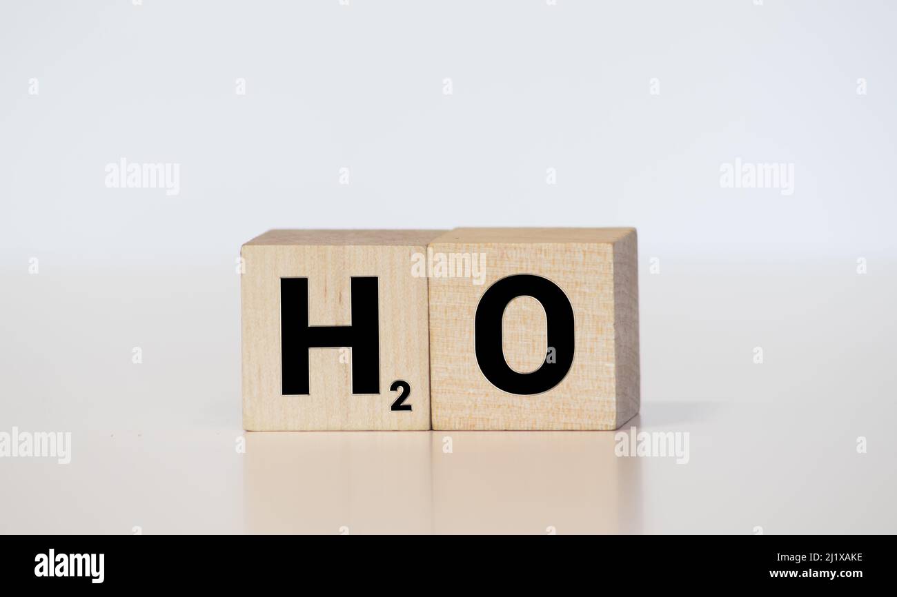 H2O - symbole chimique de l'eau dans les blocs d'impression typographiques en bois d'époque, colorés par des encres de couleur, isolés sur du blanc. Banque D'Images