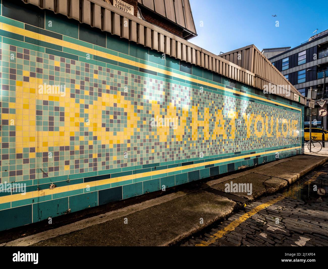 Un message en mosaïque inspiré « Do What You Love » sur la façade de la station de métro Angel originale. Rue Torrens. Londres. ROYAUME-UNI Banque D'Images