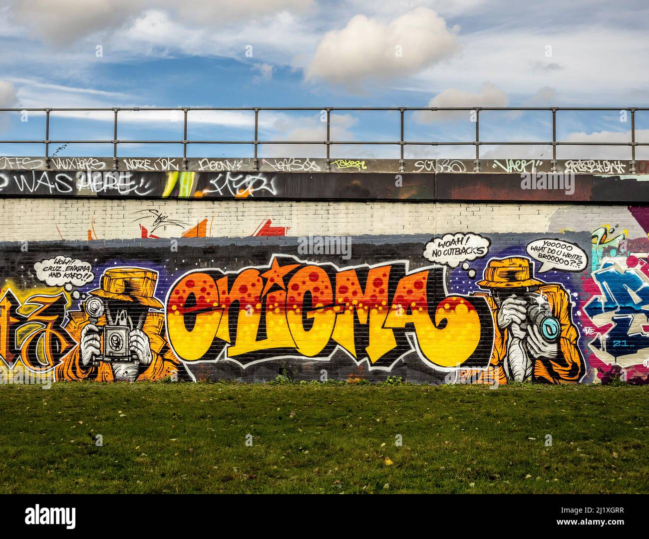 Graffiti coloré d'un paparazzo sur les murs de chemin de fer vus de Station Park, Spitalfields, Londres. Banque D'Images