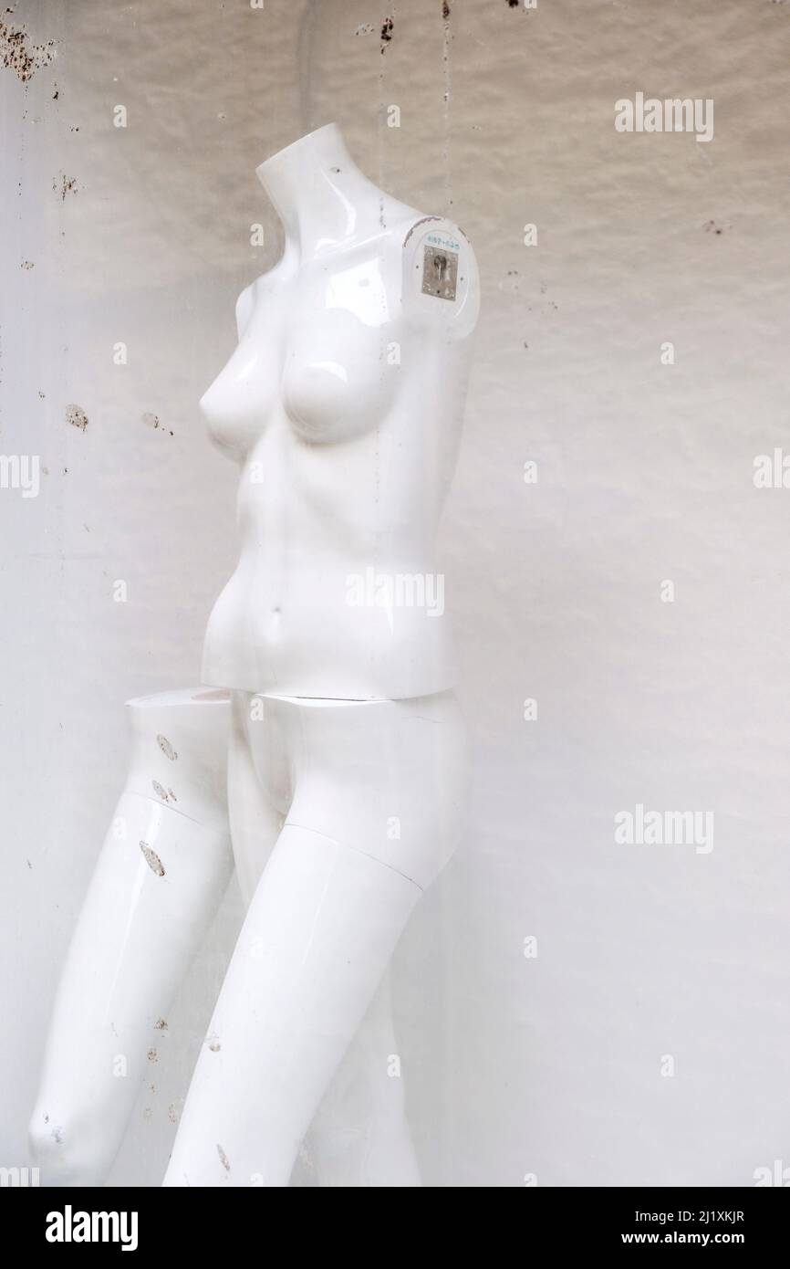 Les mannequins féminins sans bras dans une fenêtre de magasin qui a fermé, sans vêtements sur les mannequins sont nus. Banque D'Images