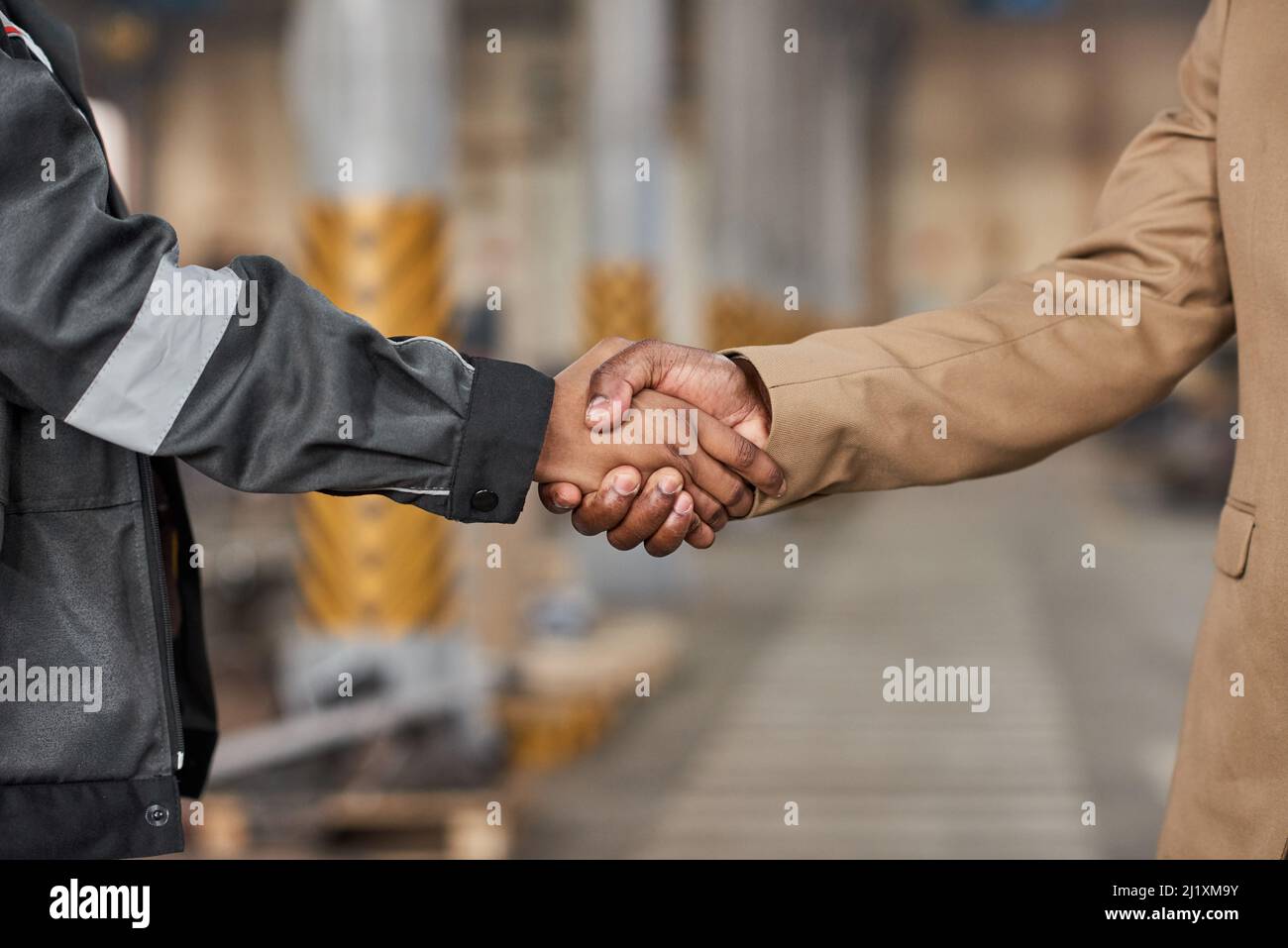 Gros plan d'un responsable qui se secoue la main avec le travailleur pour l'appliquer à un travail en usine Banque D'Images