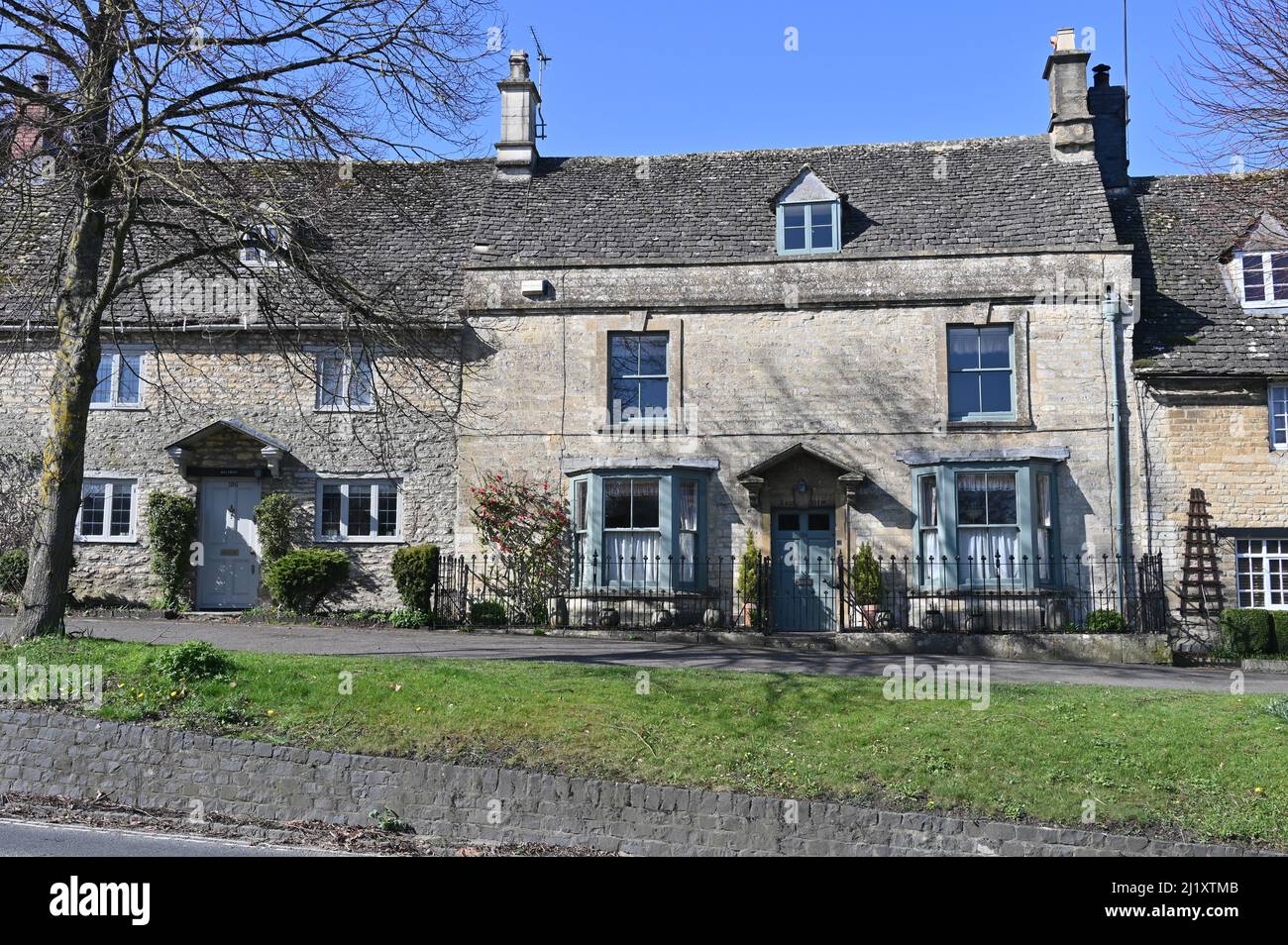 Des maisons traditionnelles en pierre bordent la partie sud de High Street dans la ville de Burford, dans l'Oxfordshire Banque D'Images