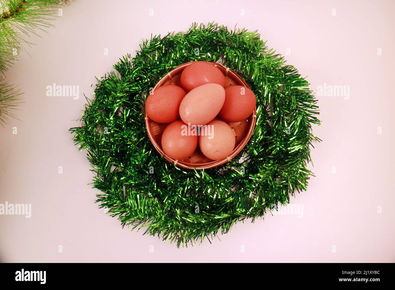 Studio photo des oeufs de Pâques dans un panier rond de vins verts sur fond blanc vue du dessus Banque D'Images