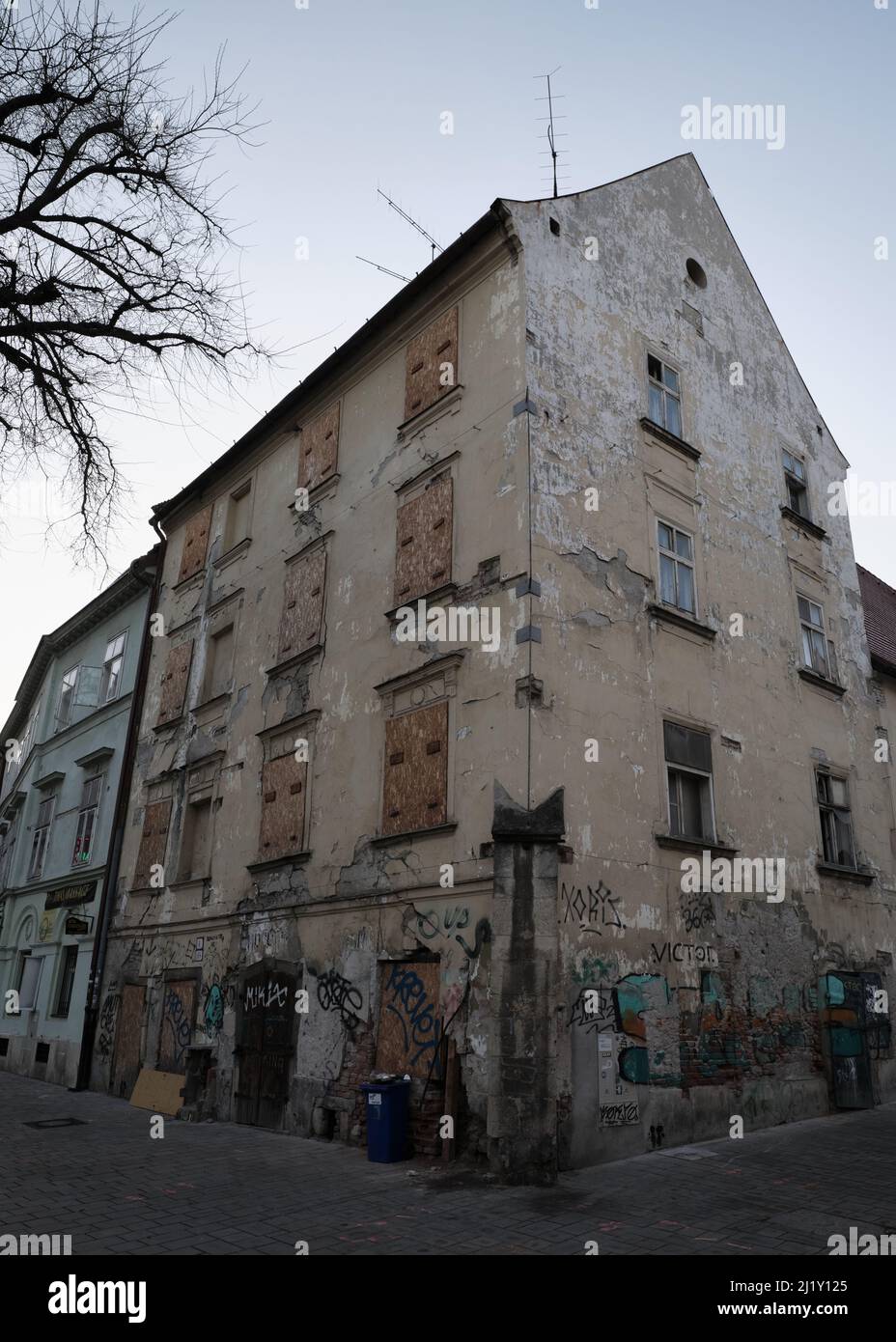 Vieux bâtiment arboré avec graffiti dans une rue calme à Bratislava, Slovaquie. Banque D'Images