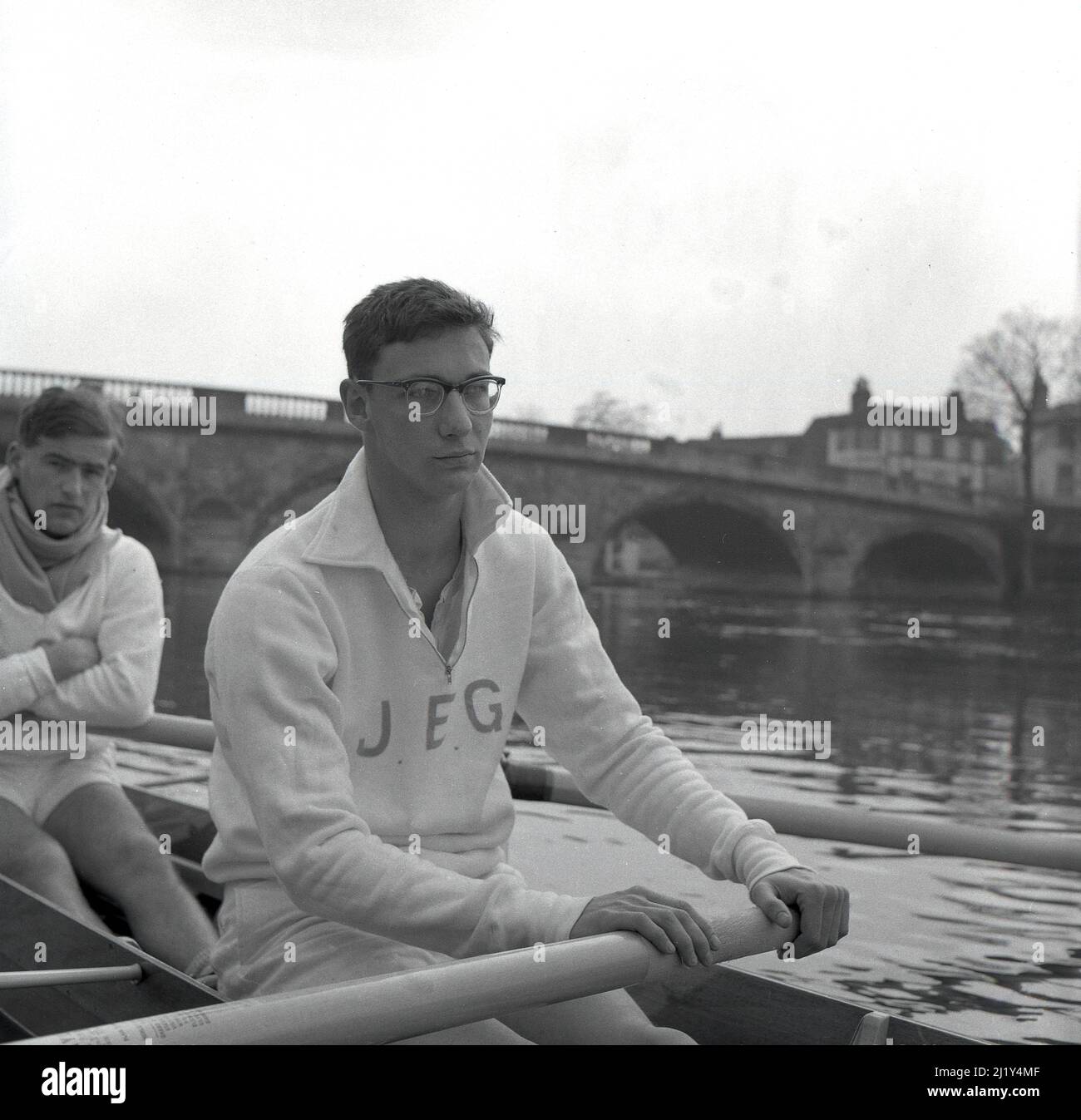 1961, photo historique montrant le rameur de l'université de Cambridge J. E. Gobbett de St Catharine's College assis dans le bateau de Cambridge sur la Tamise à Henley, en formation pour la célèbre course annuelle d'aviron, la course de bateaux d'Oxford & Cambridge. Ses initiales J.E.G sont brodrées sur son haut de survêtement en coton. Banque D'Images