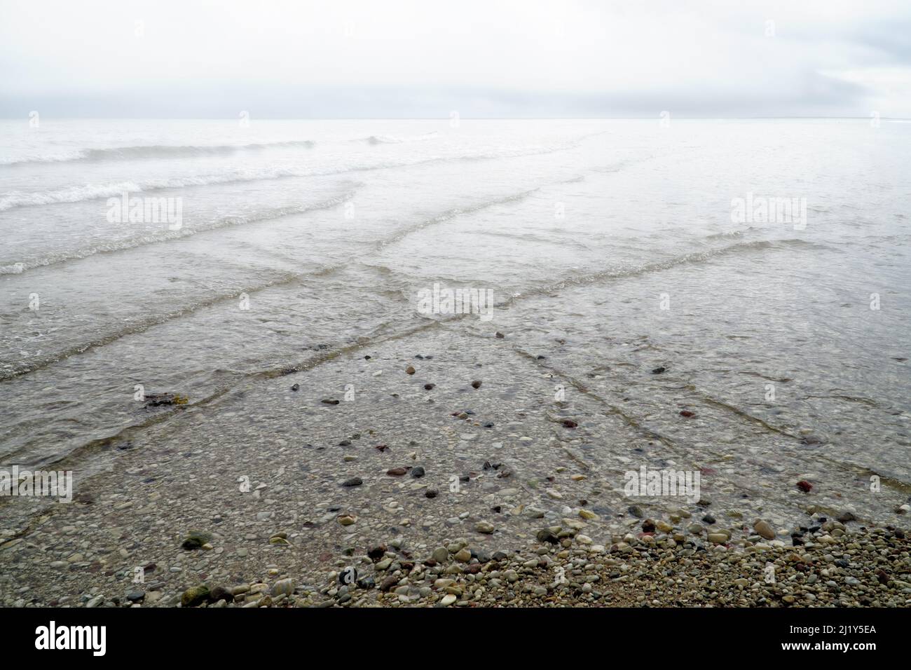 Vagues se chevauchant sur le bord de mer couvertes de brouillard avec ciel nuageux spectaculaire. Arrière-plan naturel, motif, texture de l'eau. Interferenc Banque D'Images