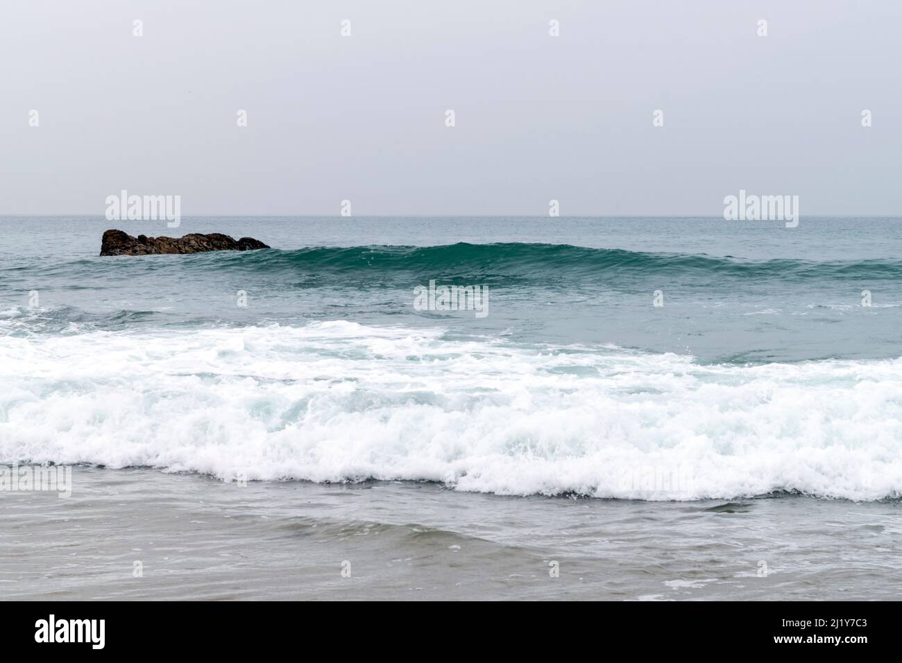 Brisez l'océan, brisez les vagues sur les rivages rocheux, gonflez l'énergie sur la côte. L'énergie océanique sur les marées hautes. Thèmes de l'océan ou de Playa avec rochers et vagues. Banque D'Images