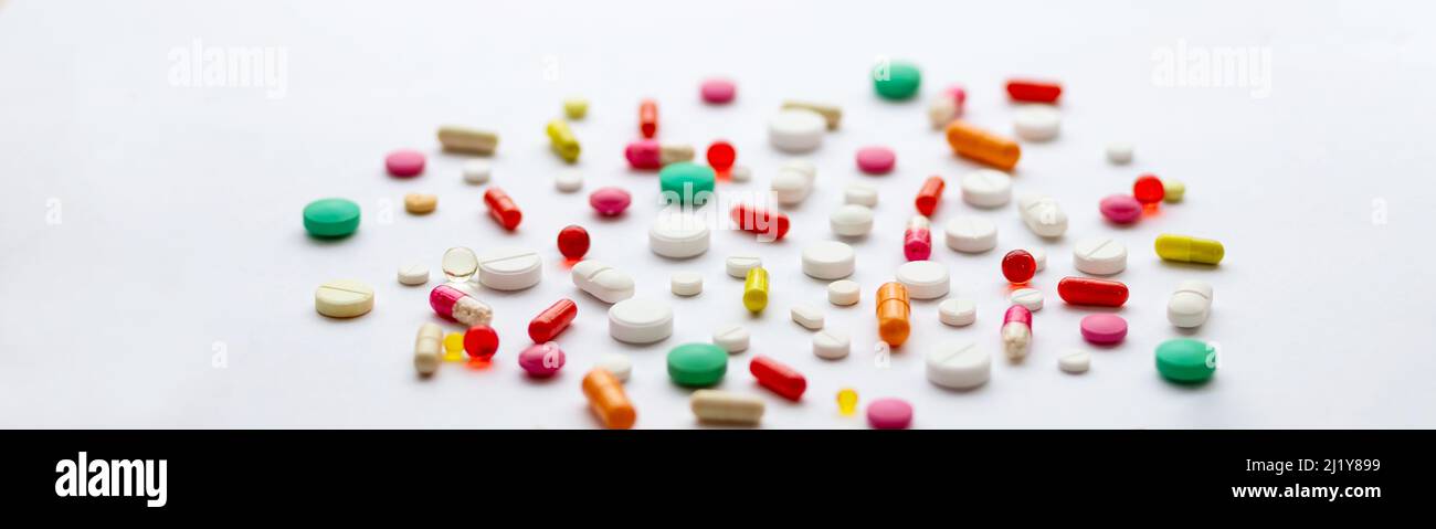 Mise en page créative de pilules et capsules colorées sur fond vert. Concept médical minimal. Banque D'Images