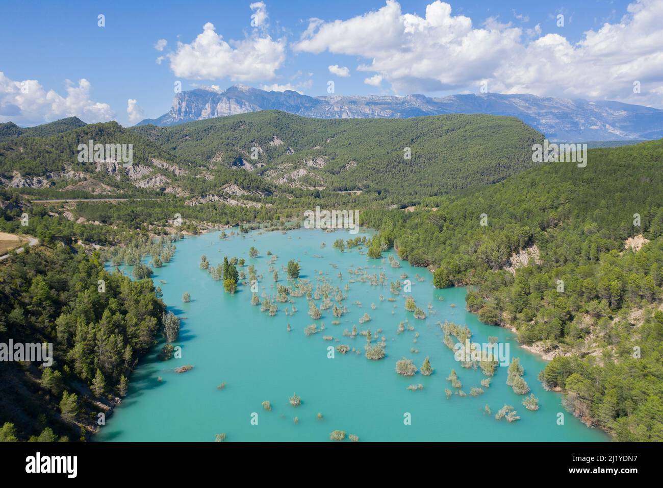 Large panorama aérien du réservoir Mediano avec des sommets lointains des Pyrénées et des couleurs estivales vibrantes près de Gerbe, Huesca, Aragón, Espagne Banque D'Images
