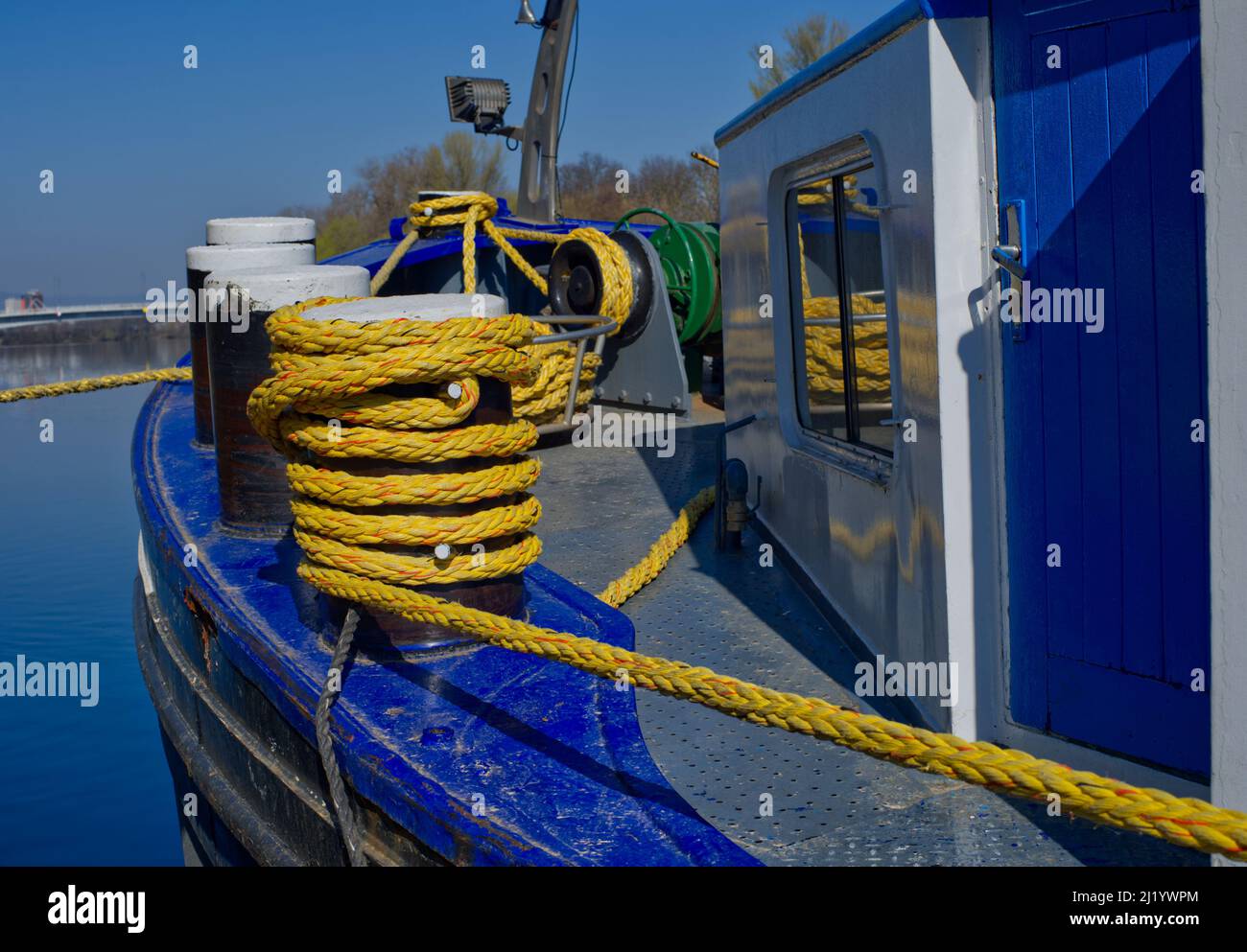 Avant d'une barge en bleu vif avec des bollards et une corde jaune (et des reflets dans une fenêtre) au bord de la rivière main, en Allemagne Banque D'Images