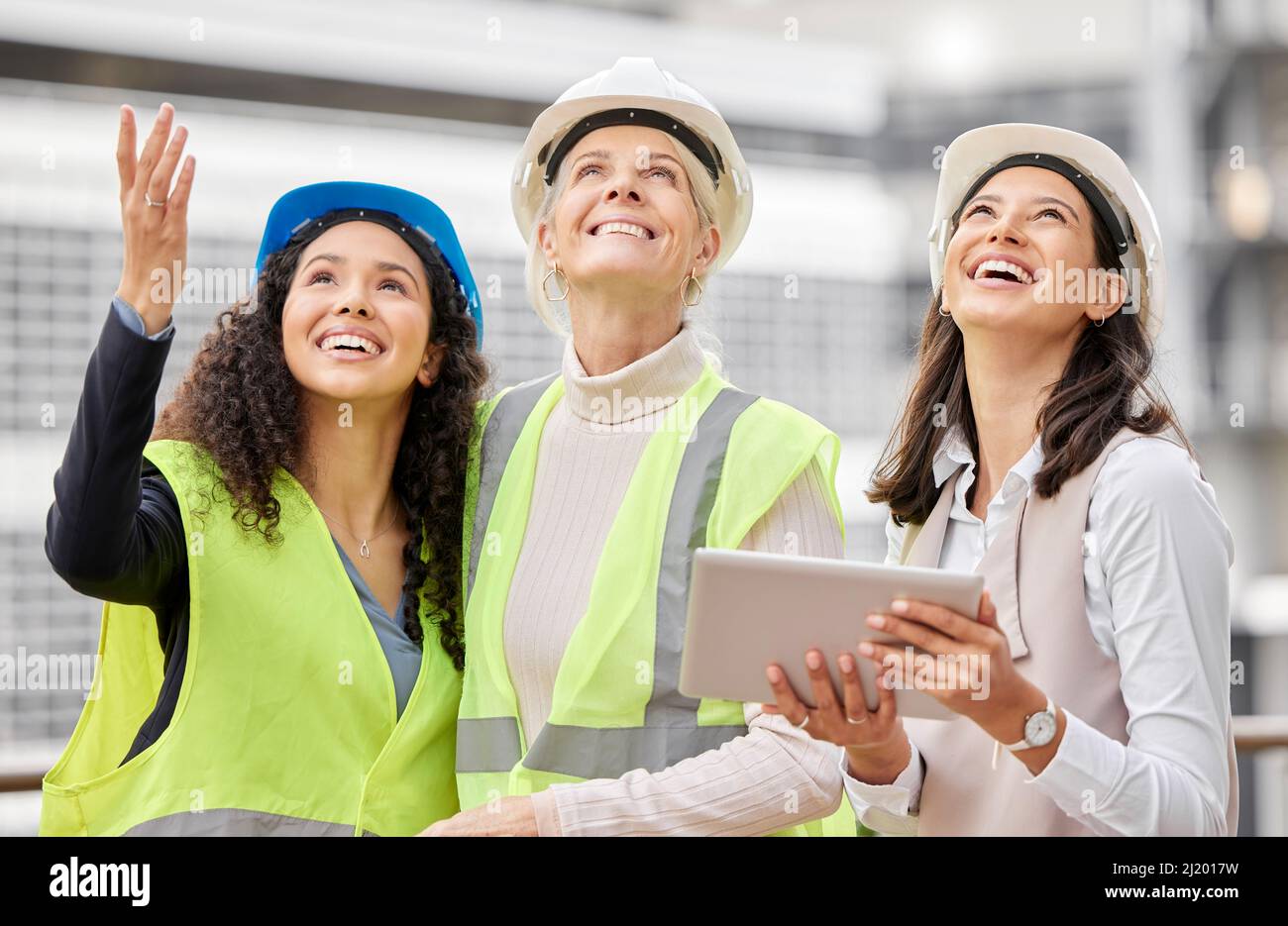 Envisager le produit final. Photo rognée de trois femmes ingénieuses utilisant une tablette tout en travaillant sur un chantier de construction. Banque D'Images