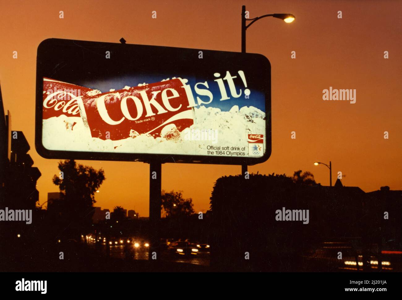 Un panneau d'affichage rétroéclairé affichant une annonce pour Coke est vu au crépuscule à Los Angeles, CA vers 1984. Banque D'Images
