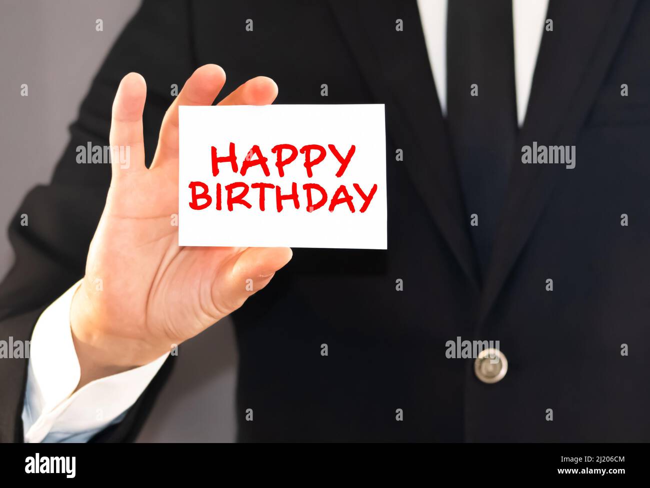 l'homme tient dans sa main une carte avec l'inscription joyeux anniversaire Banque D'Images