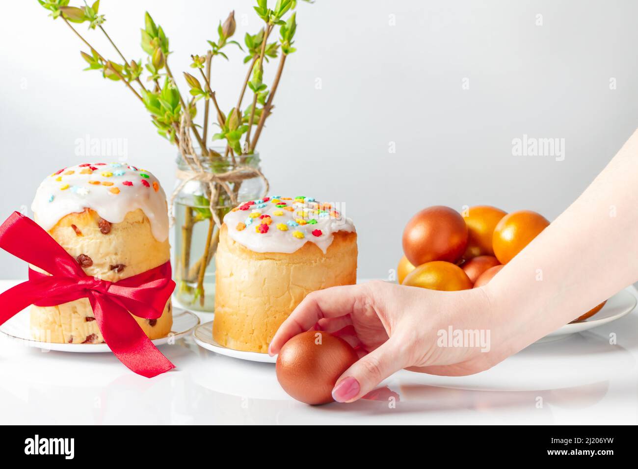 La femme met l'œuf de Pâques doré dans la pile. Concept de bonnes vacances. Banque D'Images