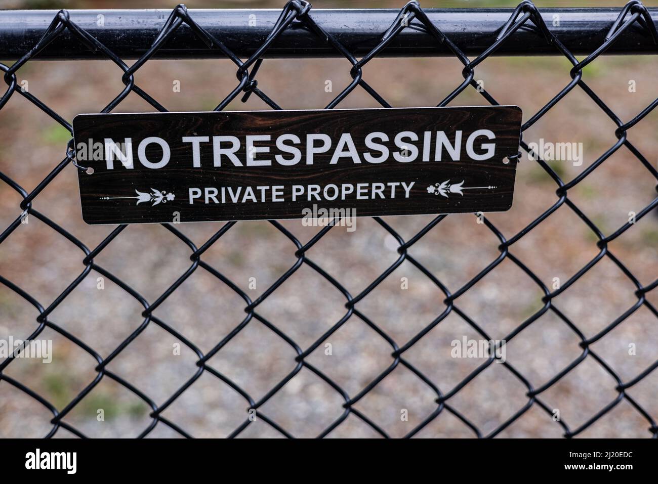 Barrière noire à maillons de chaîne sans panneau d'intrusion, menant à un avis de propriété privée. Banque D'Images