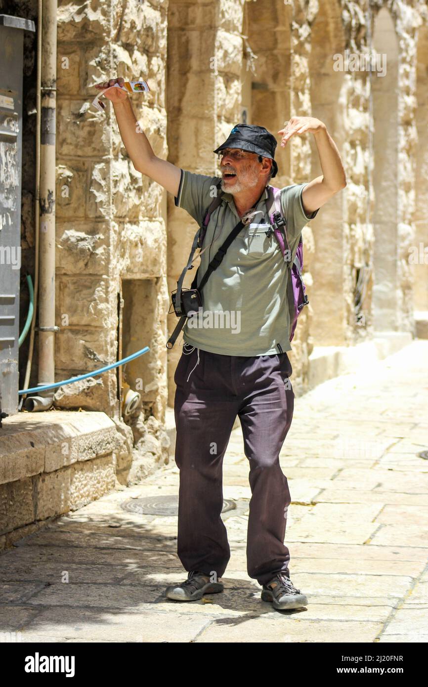 Cet homme animé avec ses bras levés sur un trottoir à Jérusalem, Israël essaie d'attirer l'attention sur un restaurant. Banque D'Images