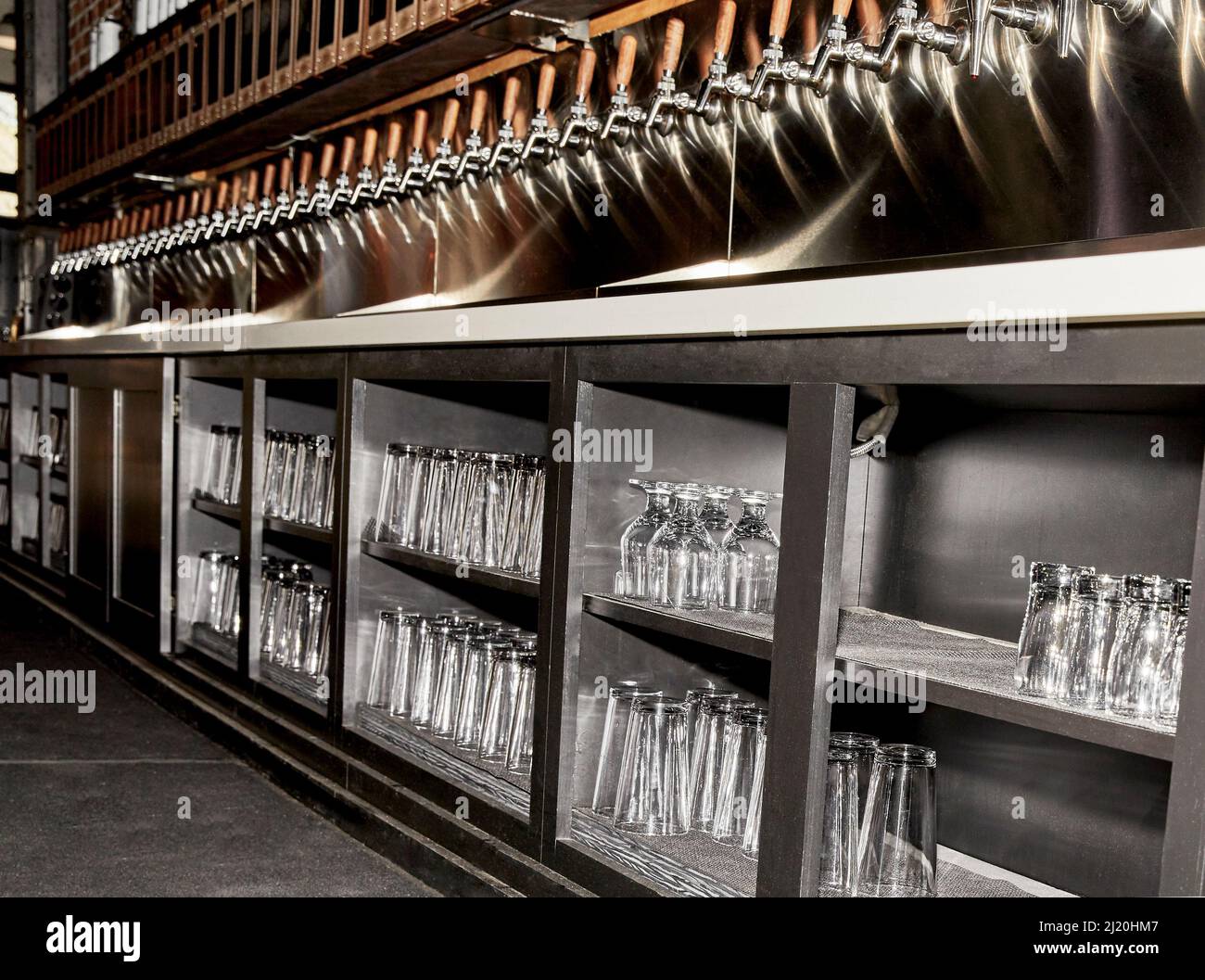 Bar libre-service sur le robinet pour les boissons alcoolisées avec des verres en dessous dans le cabinet Banque D'Images