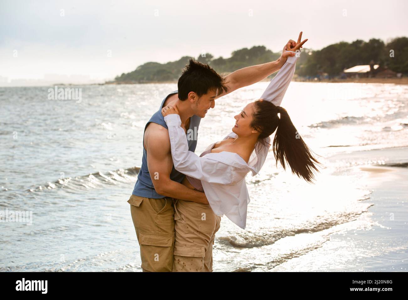 Embrasser les jeunes amoureux dansant sur la plage - photo de stock Banque D'Images
