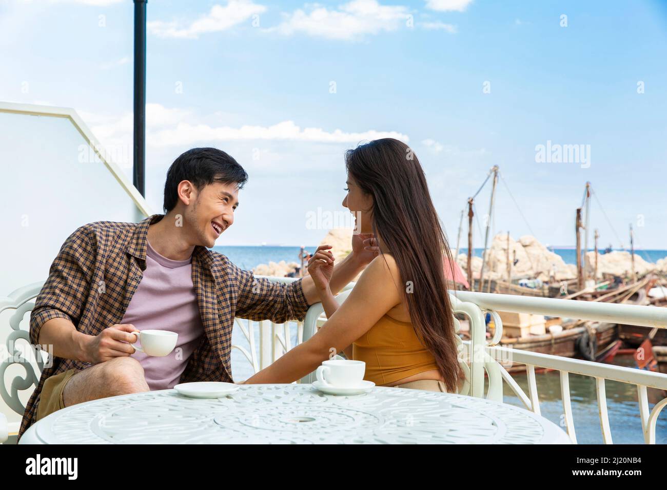 Amoureux qui sont tombés amoureux sur le balcon d'un hôtel de bord de mer - photo de stock Banque D'Images