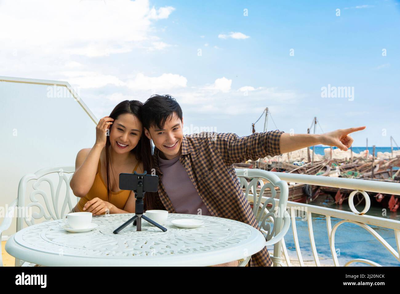 Jeunes couples discutant vidéo sur leur téléphone cellulaire au restaurant Ocean View - photo de stock Banque D'Images Jeunes couples discutant vidéo sur leur téléphone cellulaire au restaurant Ocean View - photo de stock Banque D'Images