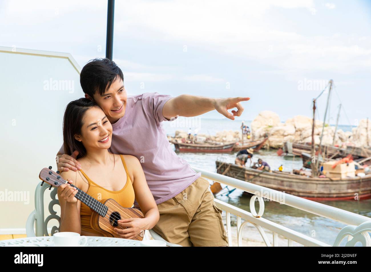 Les amoureux qui regardent le paysage à l'artiste ukulele au restaurant Ocean View - photo de stock Banque D'Images