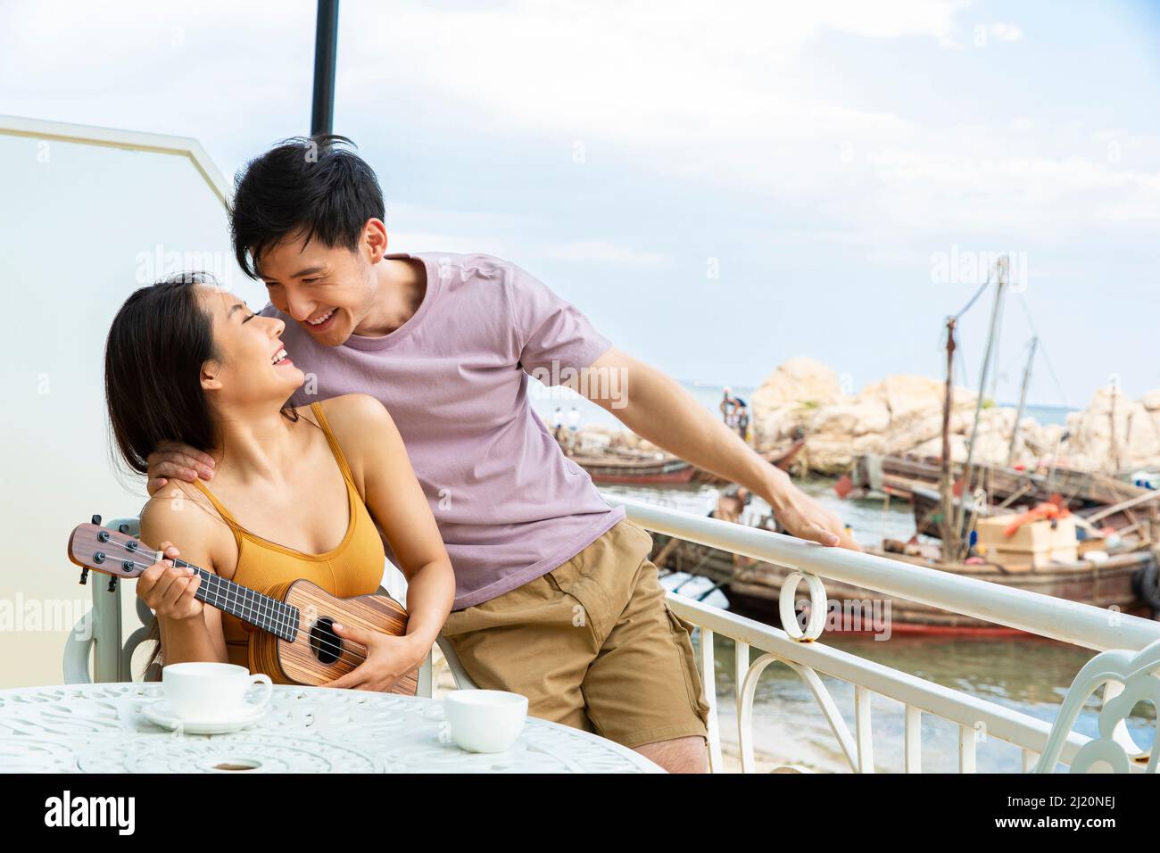 Couple jouant ukulele au restaurant Ocean View - photo de stock Banque D'Images