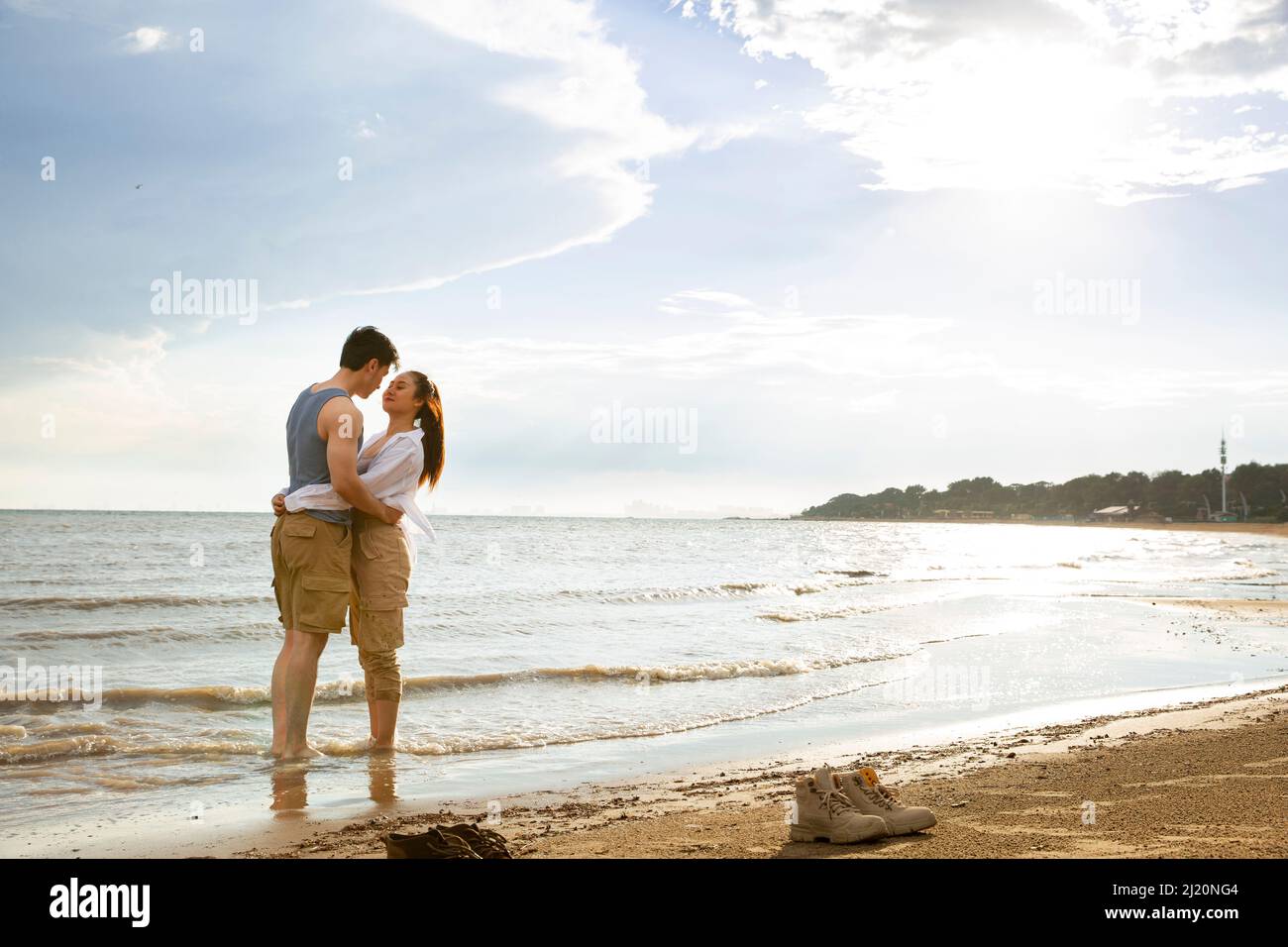 Embrasser un jeune couple pieds nus au bord de la mer - photo de stock Banque D'Images