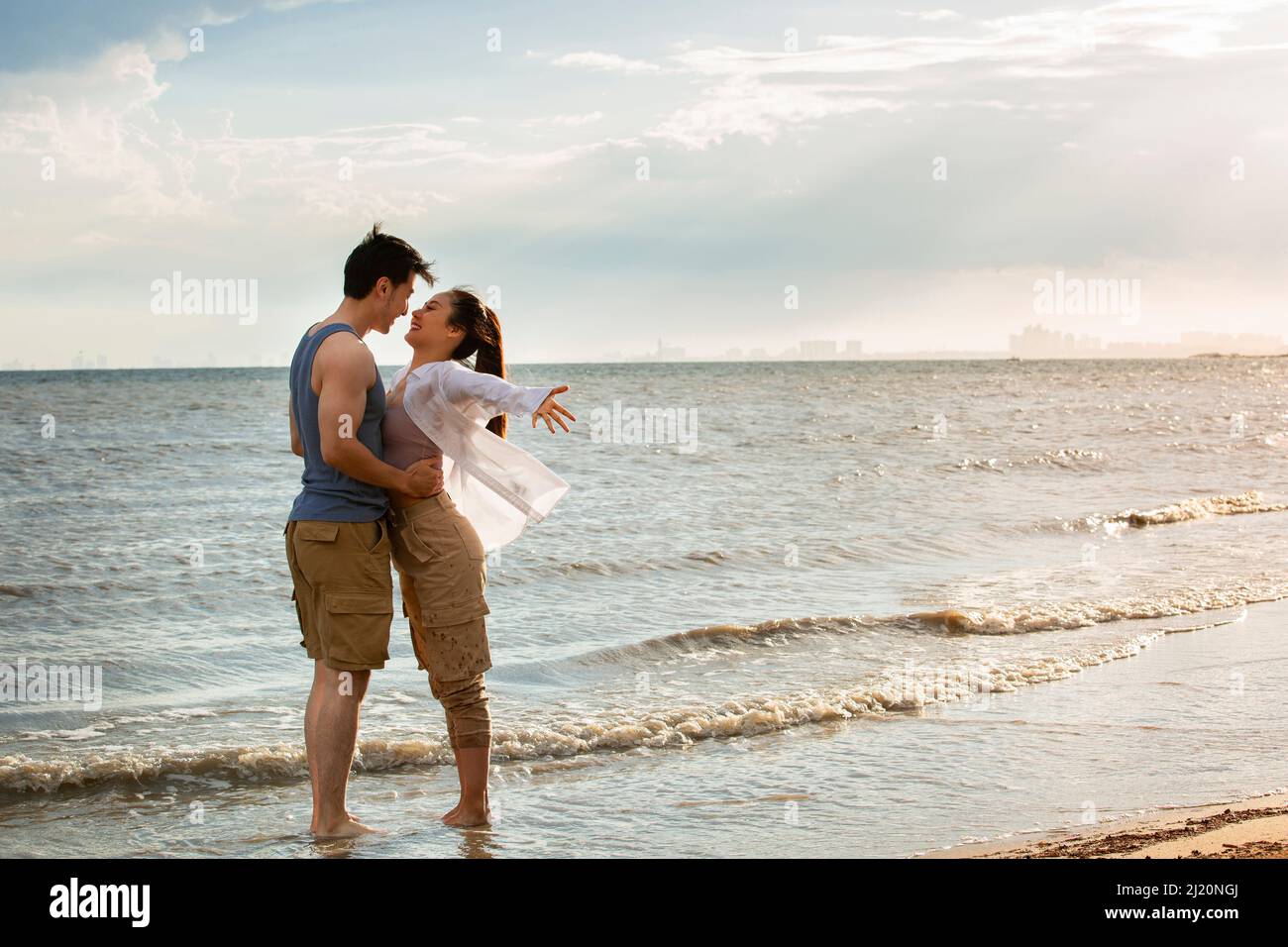 Embrasser un jeune couple pieds nus au bord de la mer - photo de stock Banque D'Images