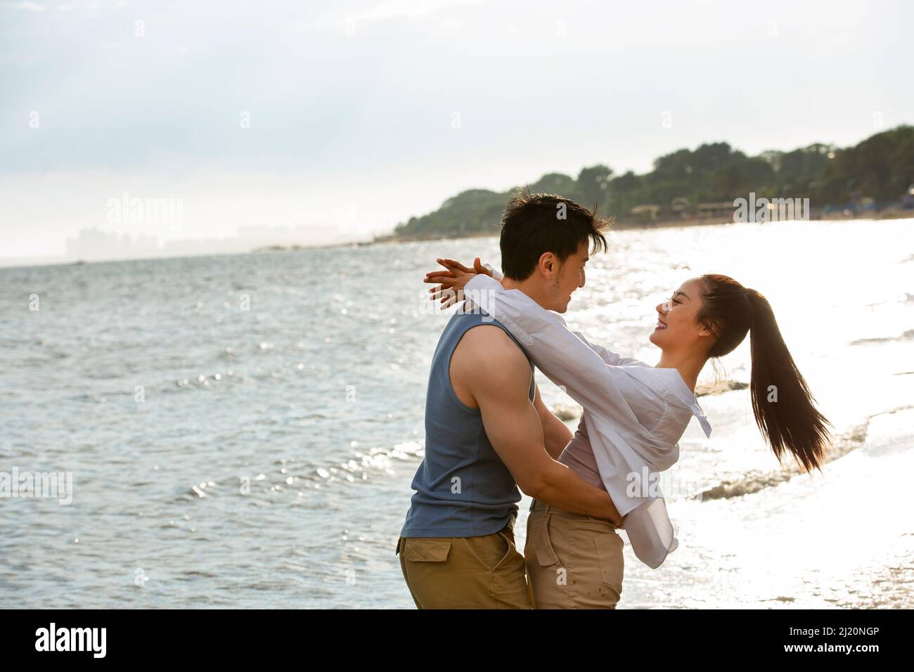 Embrasser un jeune couple pieds nus au bord de la mer - photo de stock Banque D'Images