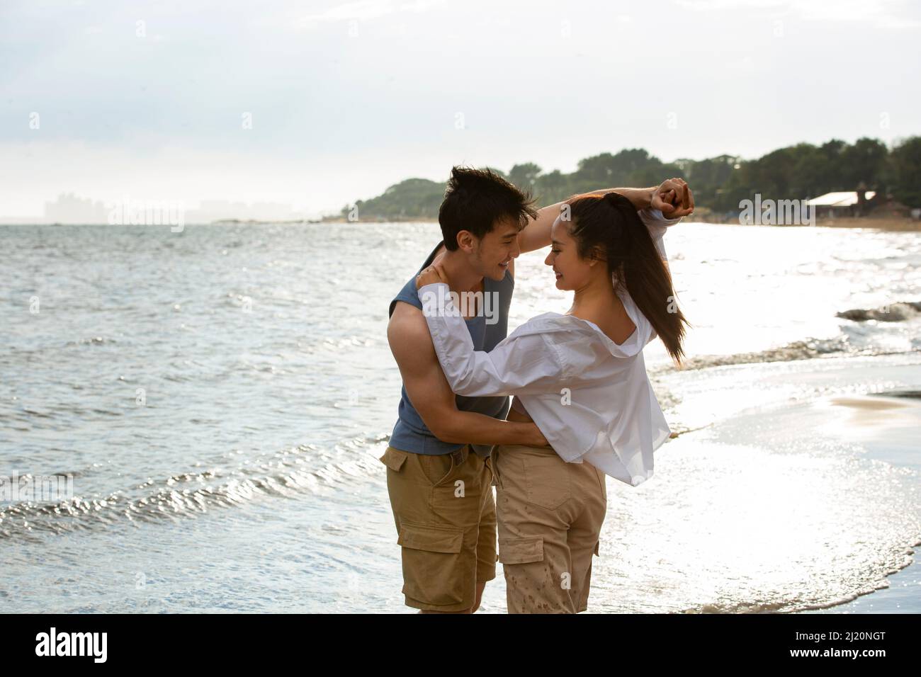 Embrasser les jeunes amoureux dansant sur la plage - photo de stock Banque D'Images
