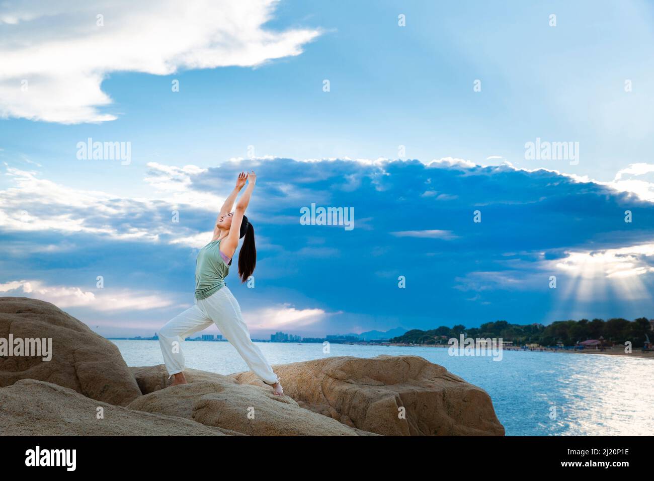 Belle jeune femme pratiquant le yoga sur le récif de la plage - photo de stock Banque D'Images