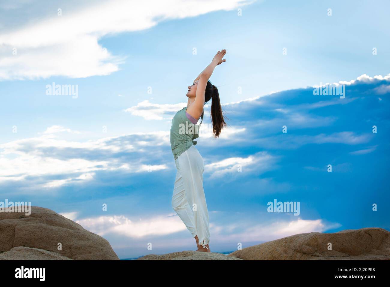 Belle jeune femme pratiquant le yoga sur le récif de la plage - photo de stock Banque D'Images