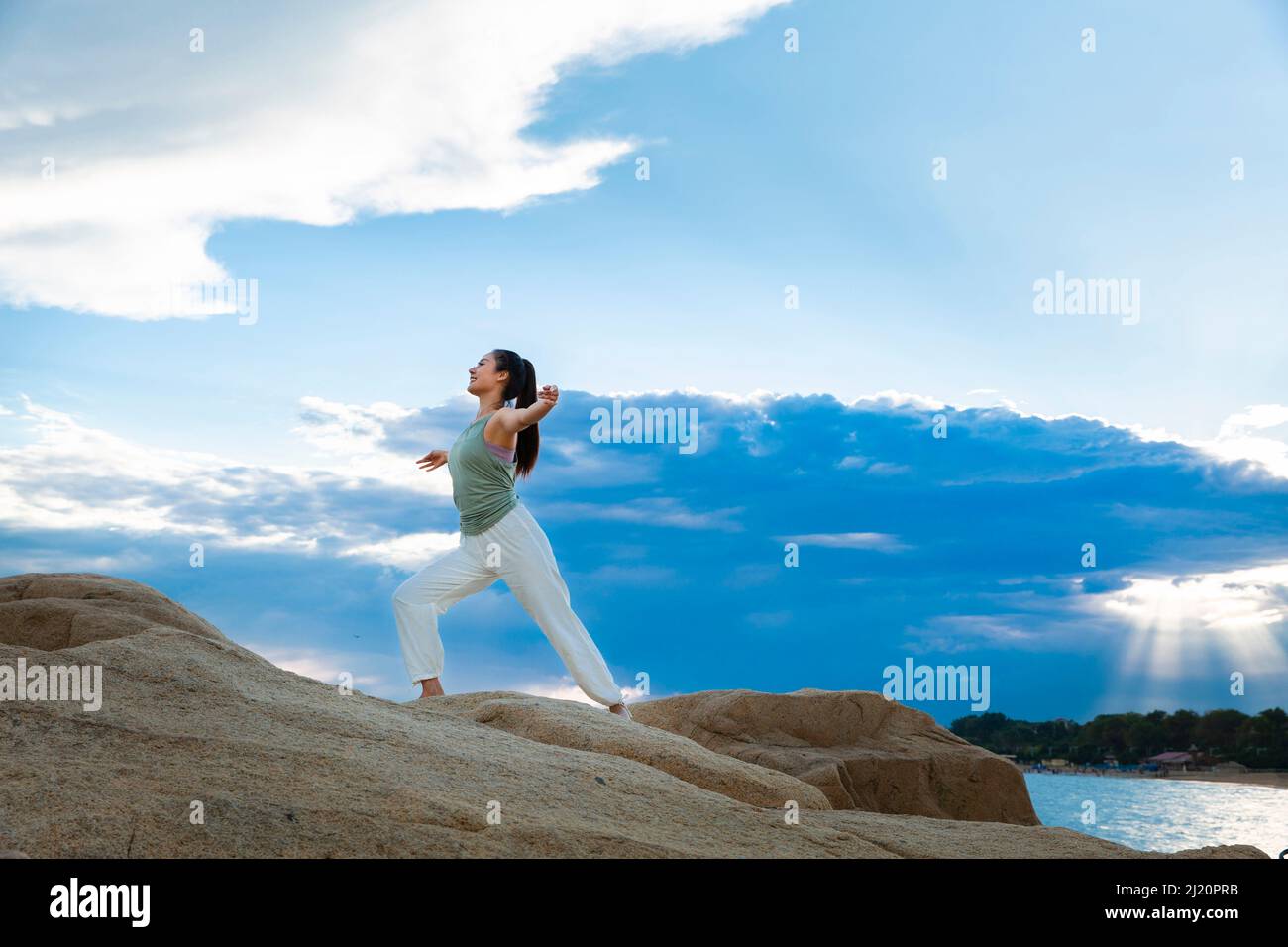 Belle jeune femme pratiquant le yoga sur le récif de la plage - photo de stock Banque D'Images