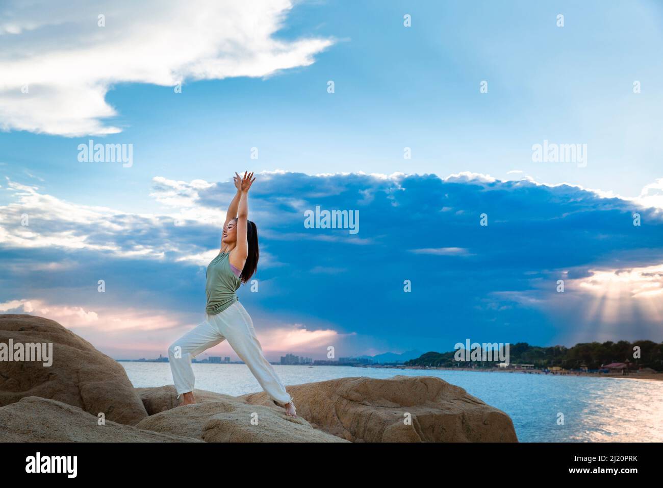 Belle jeune femme pratiquant le yoga sur le récif de la plage - photo de stock Banque D'Images
