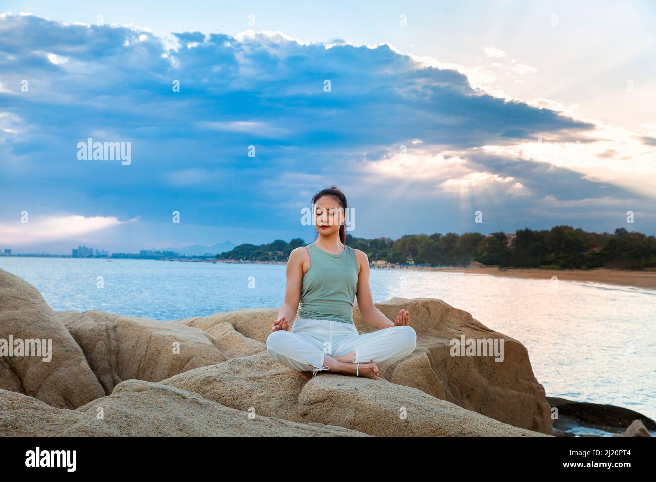 Belle jeune femme pratiquant le yoga sur le récif de la plage - photo de stock Banque D'Images