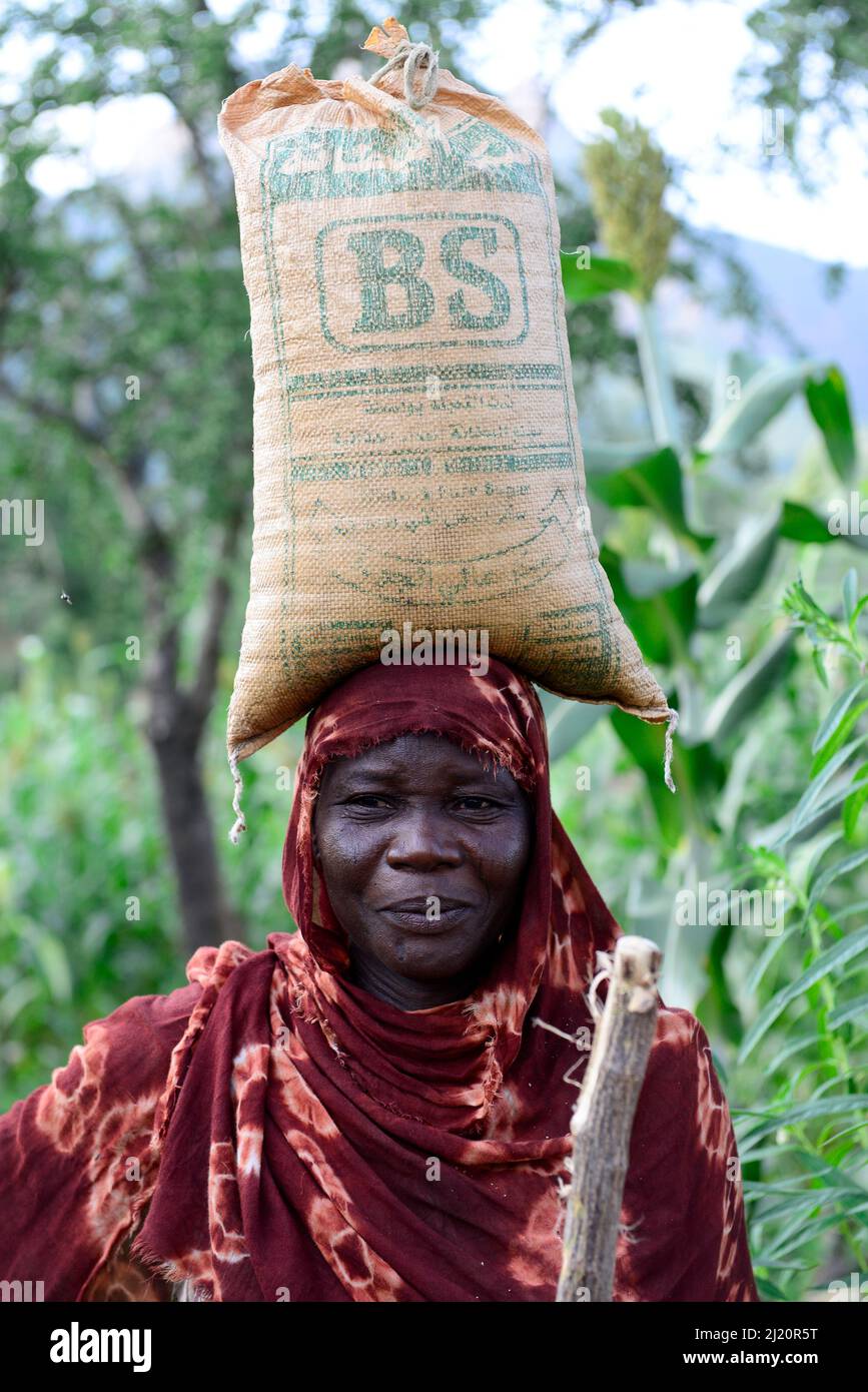 Hadjarai femme, portant un grand sac équilibré à la tête, village de Moukoulou. Tchad du Sud. Septembre 2019. Banque D'Images