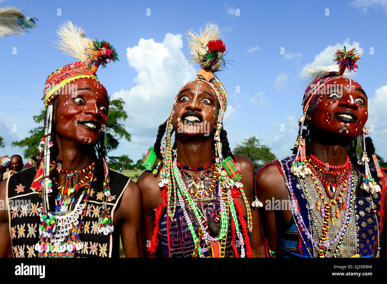 Trois hommes de la tribu nomade Wodaabe célébrant Gerepol, un rassemblement de clans différents dans lequel les femmes choisissent un mari. Les hommes s'habillent dans les meilleurs vêtements et Banque D'Images