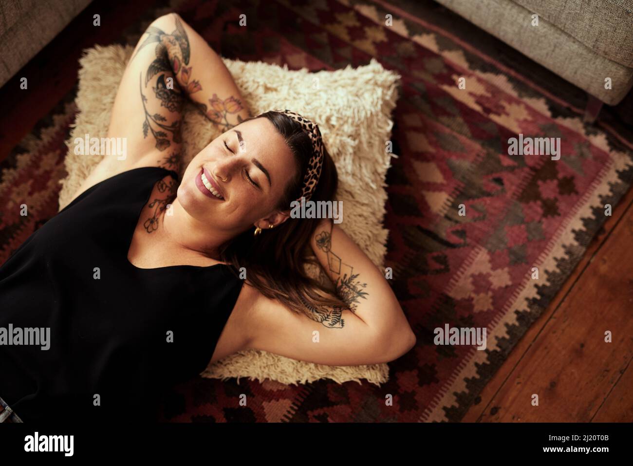 Reposez-vous sur le bonheur. Photo d'une jeune femme se reposant sur le sol de son salon à la maison. Banque D'Images