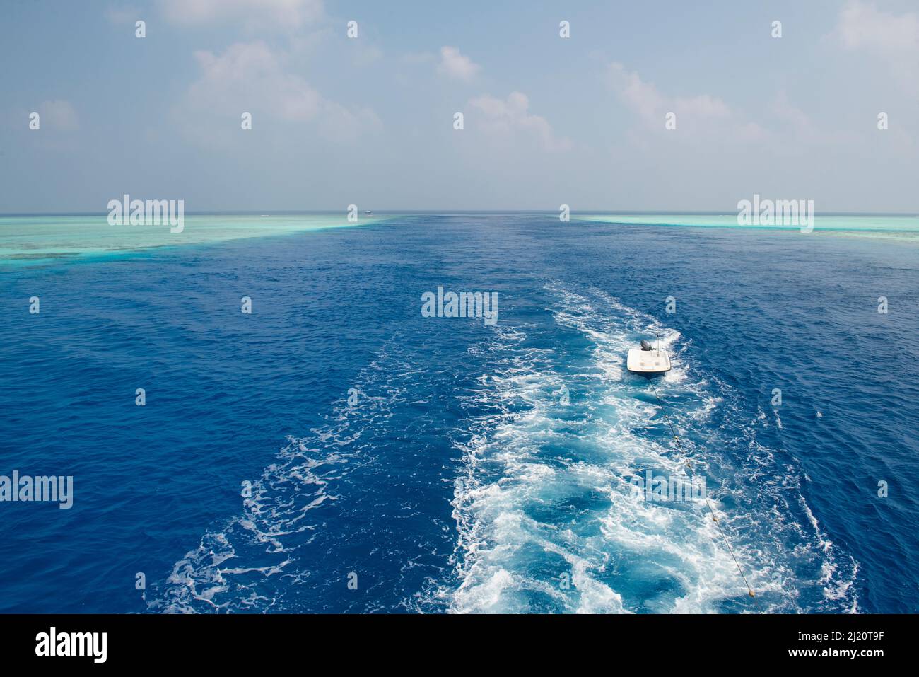 Vue panoramique panoramique sur l'océan tropical à travers le canal dans l'atoll de récif de corail avec réveil en bateau Banque D'Images