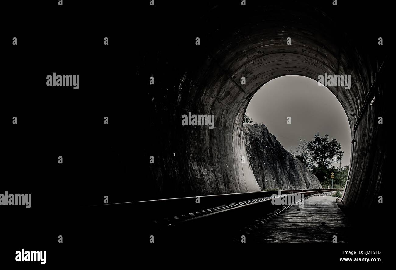 A l'intérieur du tunnel ferroviaire et des chemins de fer avec lumière naturelle à la fin. Lumière à la fin du tunnel, lumières et ombres, concept de réalisation de votre g Banque D'Images