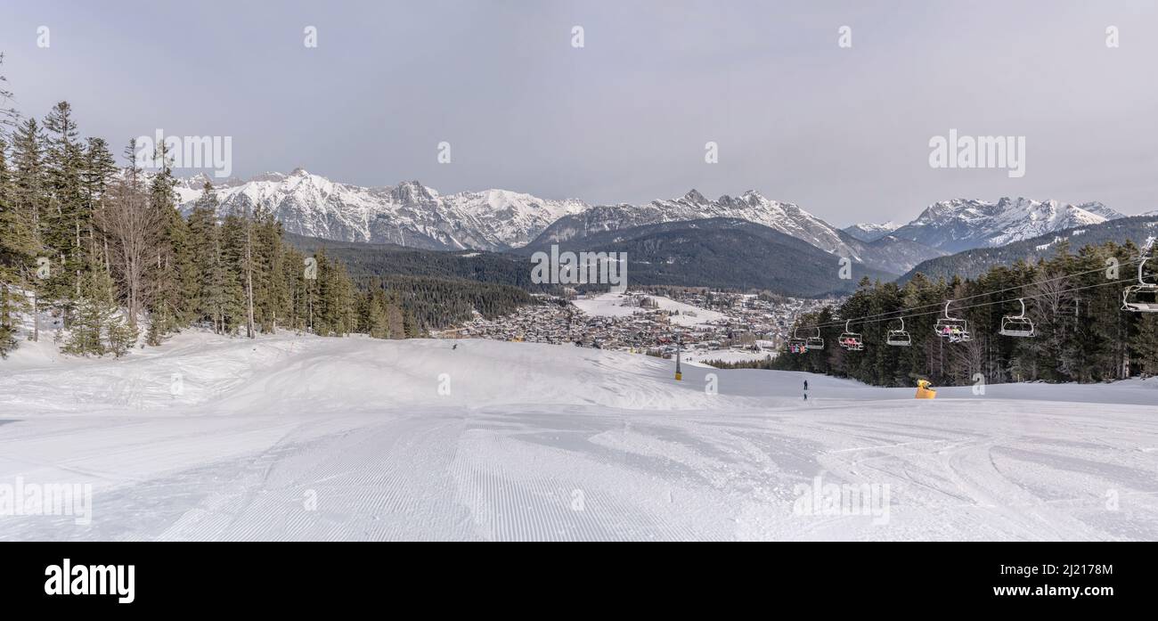 Paysage de montagne d'hiver avec piste de ski enneigée au milieu des bois de Gschwandkopf, tourné en lumière vive à Seefeld, Tyrol, Autriche, Banque D'Images