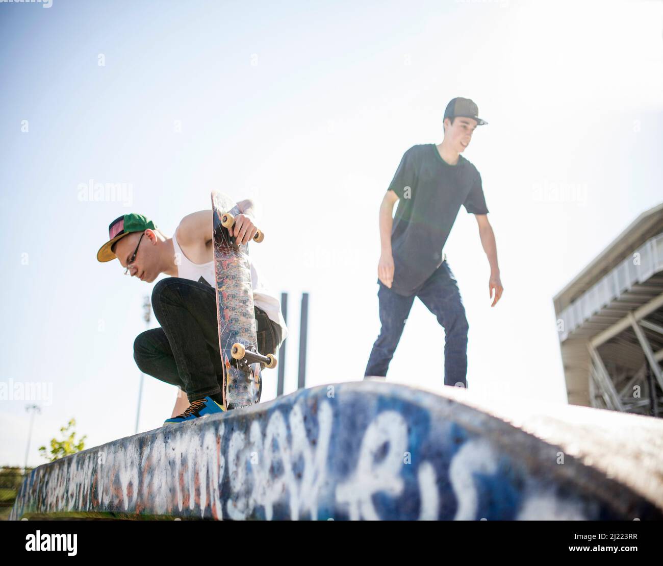 Deux jeunes skate, dans un parc de skate. Banque D'Images